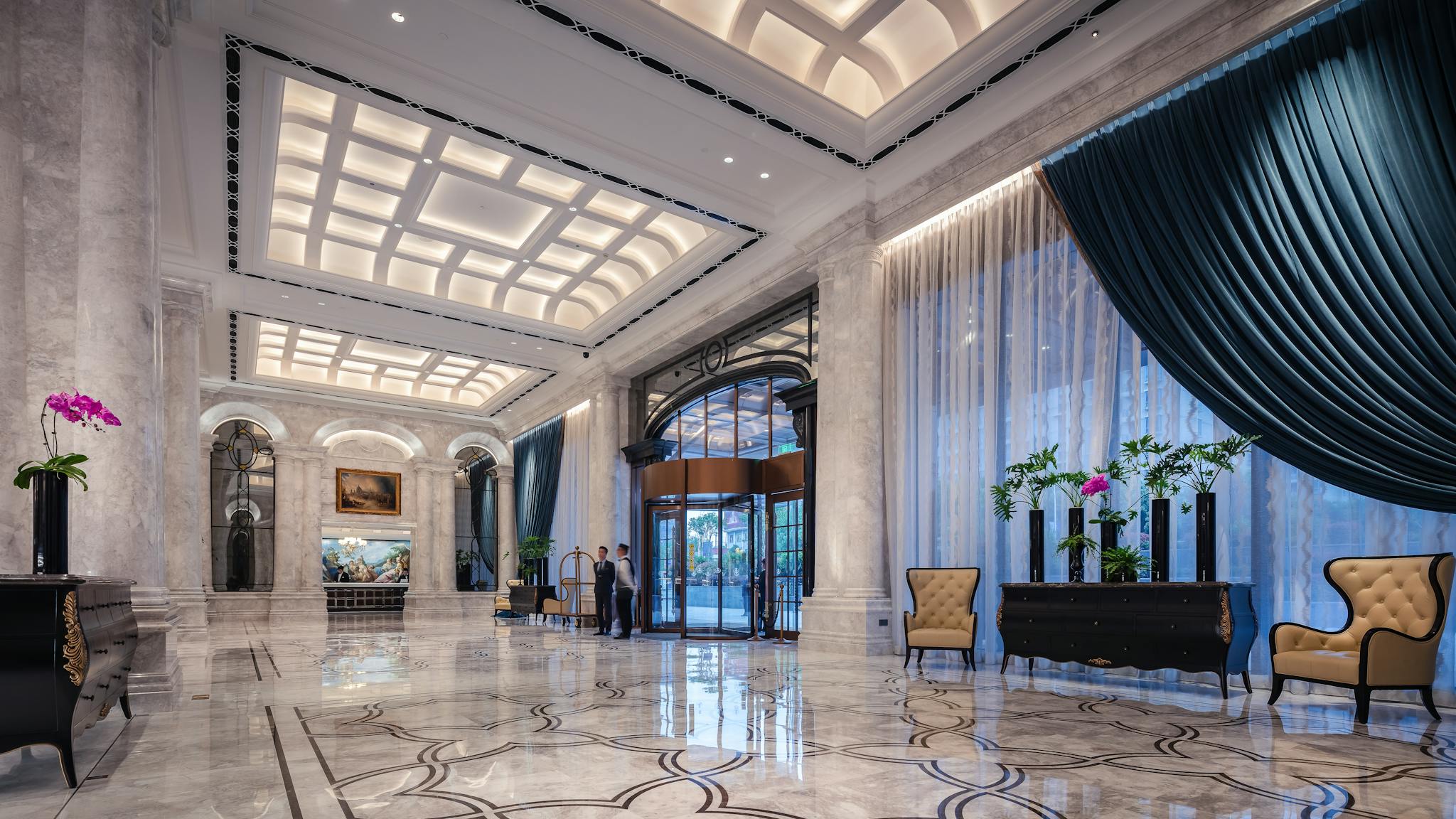 Elegant hotel lobby with high ceilings, marble floors, and opulent decor.